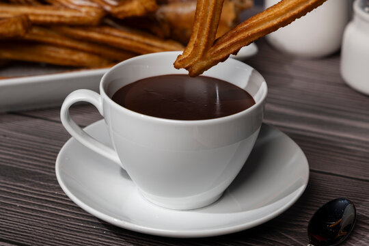 Golden fried churros served with cup of chocolate