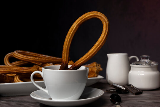 Close up of churros with cup of hot chocolate on rustic table