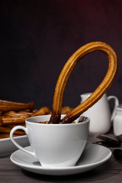 Traditional Spanish churros with hot chocolate on rustic wooden table