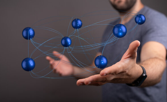Abstract image representing interconnectedness, technology, data, and communication. A hand holds a network of blue sph