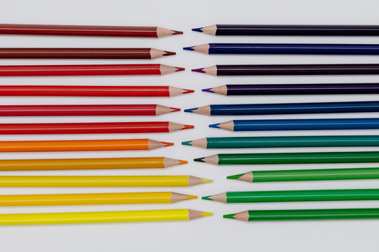Rainbow Colored Pencils facing eath other on Black Background