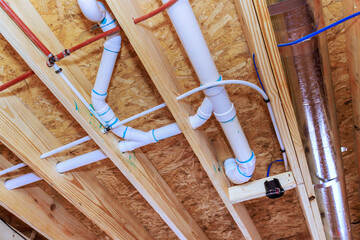 Obraz na płótnie Canvas Pipes ducts installed under wooden ceiling in construction site for building project