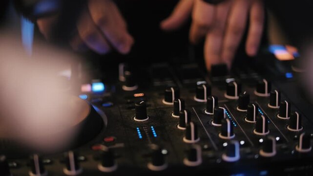 DJ mixing music on professional controller at nightclub party