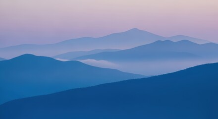 Obraz premium Misty Mountain Layers at Sunrise: Blue Hues and Soft Light