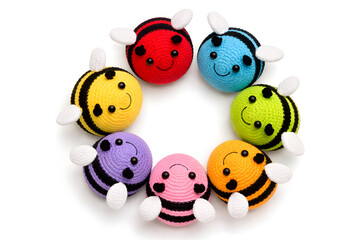 Seven Colorful Crochet Bee Toys Arranged in Circular Pattern on White Background &ndash; Handmade Amigurumi Plush Collection