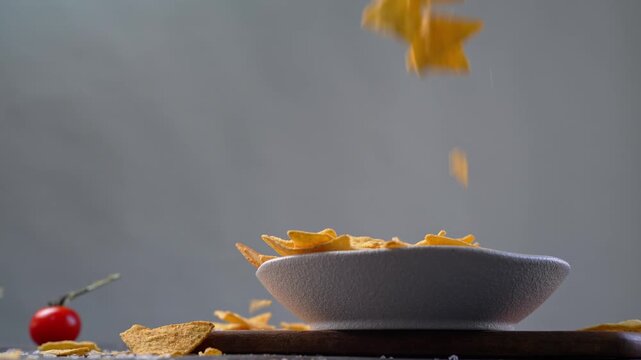 Slow Motion Shot of Falling Tortillas chips in a white bowl. Modern minimal shot, hero view