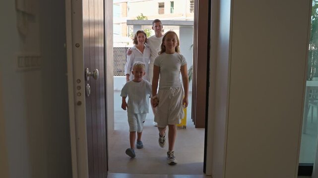 Happy family with children and luggage entering their new home or vacation rental, showcasing joy of arriving at holiday apartment or moving into house.Family lifestyle, holiday, moving, and travel