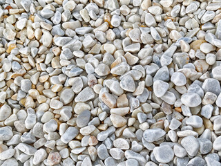 Natural smooth pebbles scattered on a surface for landscaping and decorative purposes