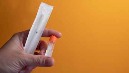 Hand holding home DNA testing kit with saliva sample tube for genetic ancestry test © Svetlana