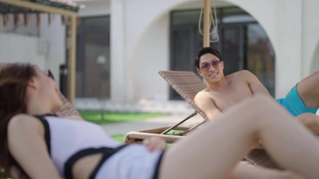 Young couple lounging by the pool on their dream vacation