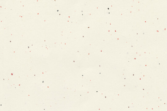 Light beige paper sheet with subtle red and black speckles. Abstract speckled grain paper texture for craft material or background design
