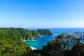 Naklejka premium Turquoise coastal bay and forested cliffs along Shikoku Henro pilgrimage trail in Shikoku Japan