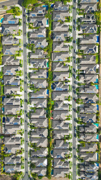 Aerial view of rows of houses with pools glisten under the sun, an urban tapestry of repeating patterns and geometric precision, Honolulu, Hawaii, United States.