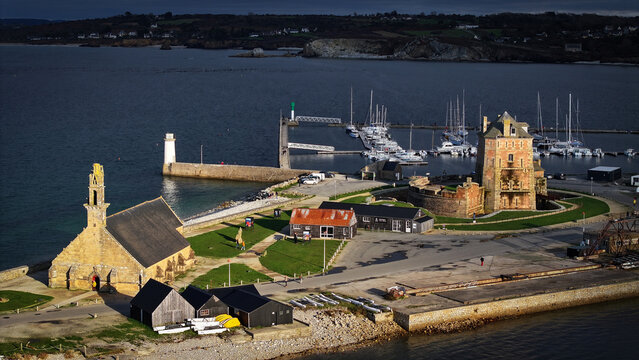 Aerial view of the Vauban tower standing proudly next to the church of Notre Dame de Rocamadour, as boats are docked in the port, Camaret-sur-Mer, Bretagne, France.