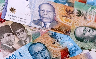 Indonesian rupiah money bills pile on table. Indonesia banknotes of IDR currency close up. © Larysa