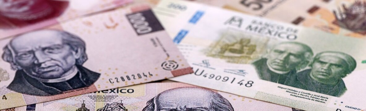 Mexican peso money bills pile on table. Mexico banknotes of MXN currency close up.