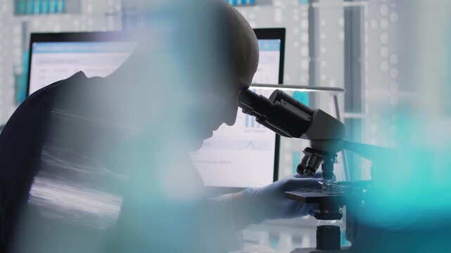 Male scientist or a doctor in protective glove working in a laboratory. Typing on a computer