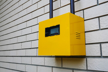 Yellow gas meter on a white wall.