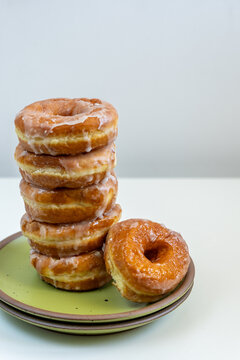 Stack of glazed donuts on a green plate 