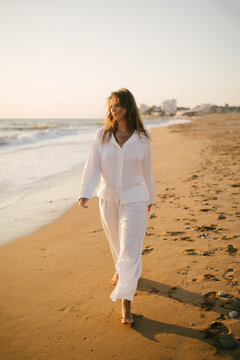 Beautiful 40 years old woman relaxing on the beach at sunset.