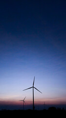 Obraz premium Renewable Energy Wind Turbine Landscape with Sunset Sky Backgrou
