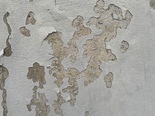 Peeling paint texture on old plaster wall with stains and weathered surface, distressed grunge background of cracked coating and aged facade material