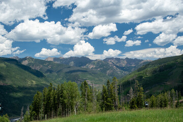 Fototapeta premium Wide Rocky Mountain Valley Landscape Under Blue Sky with Clouds, Vail Colorado
