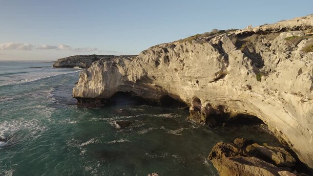 4k 60p footage of the rocky coastline near Waenhuiskrans Cave, Arniston. Towering cliffs meet ocean waves in Overberg seascape, Western Cape, South Africa. Ideal for nature and travel visuals.