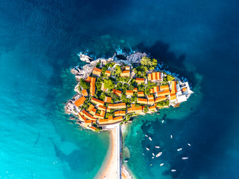 Aerial view of the iconic Sveti Stefan island, a jewel of red-roofed buildings and lush greenery embraced by the turquoise Adriatic sea, Sveti Stefan, Budva Municipality, Montenegro.