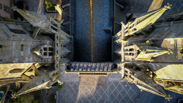 Aerial view of the architectural details of the Cathedral with its pointed spires and intricate stone work, bathed in the warm glow of the sun, Saint-Pol-de-Leon, Brittany, France.