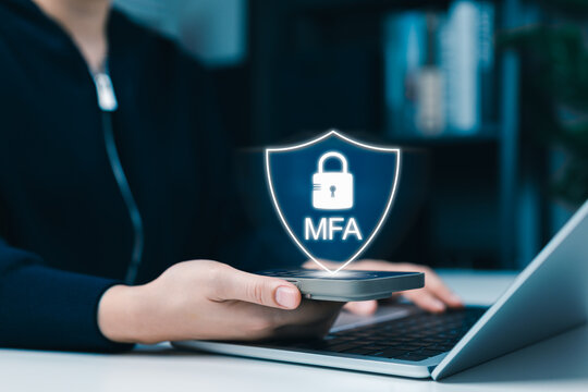 MFA Multi-factor authentication concept. shield icon on smartphone, User performing secure login, data protection and cybersecurity while using laptop. identity verification, online account security