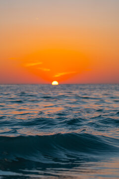 Sunset. Warm sunset over the ocean horizon with soft sea waves and glowing orange sky. Peaceful seascape at golden hour showing calm water, natural light and relaxing coastal evening atmosphere
