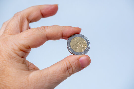 Single two euro coin textured surface, close up European currency, cash money and economy concept, finance and savings, metallic bimetallic coin detail, micro-payments, pocket money macro photography