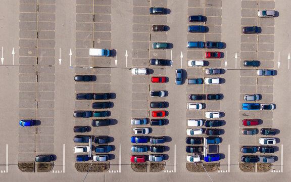 Aerial view of orderly rows of parked cars, a colorful mosaic against the gray asphalt, reflecting the city's pulse from above, Warsaw, Masovian Voivodeship, Poland.