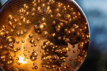Macro de presse-papier en verre ambré avec bulles d'air et reflets dorés