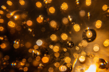 Macro de presse-papier en verre ambré avec bulles d'air et reflets dorés