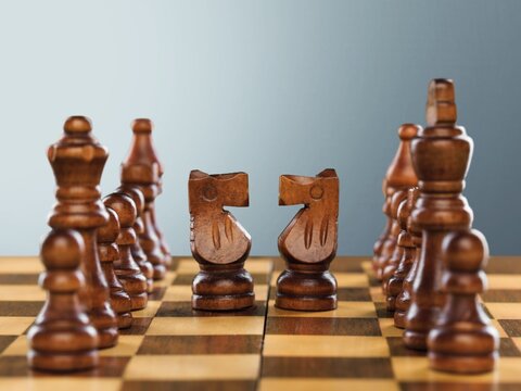 Wooden chess figures on a classic chessboard