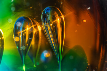 Sphère de cristal irisée et jeux de lumière abstraits sur fond sombre.