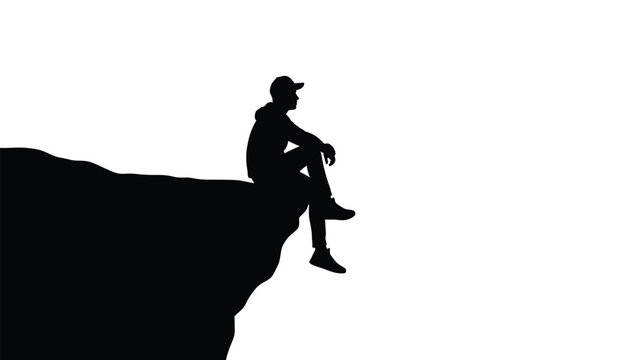 A silhouette of a lone person wearing a cap sitting on the edge of a high cliff looking forward