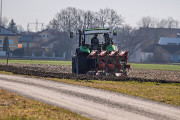 Fototapeta premium Tractor plowing a field early in the morning