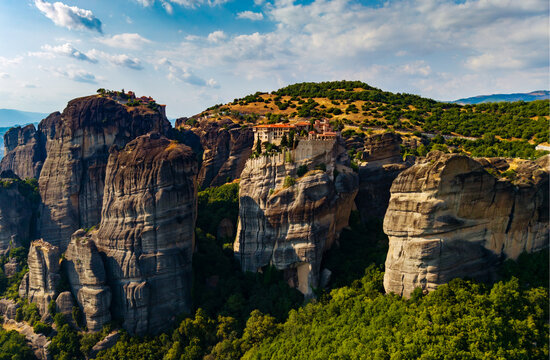 Aerial view of monasteries perched atop towering rock formations, where ancient architecture meets the vast sky, Meteores, Trikala, Greece.
