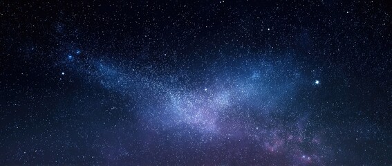 Obraz premium Vast Milky Way Galaxy stretching across a dark starry night sky with vibrant blue and purple nebulae.