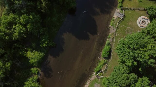 Flying over the Credit River in Cheltenham area, a community within the town of Caledon, Ontario, Canada. Shot by a drone looking straight down from overhead, on a hazy summer afternoon.