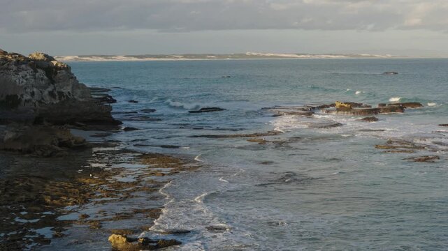 4k 60p footage of stunning turquoise waters along Arniston&rsquo;s beautiful Overberg coastline with sand dunes visible in the background. Western Cape, South Africa. Iconic, remote coastal serenity.