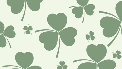 Seamless pattern design featuring various sizes of green three leaf clovers scattered across a light cream colored background.