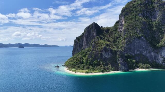 Cinematic aerial video of tropical island in the Philippines with lime stone rock, palm trees and beautiful beach
