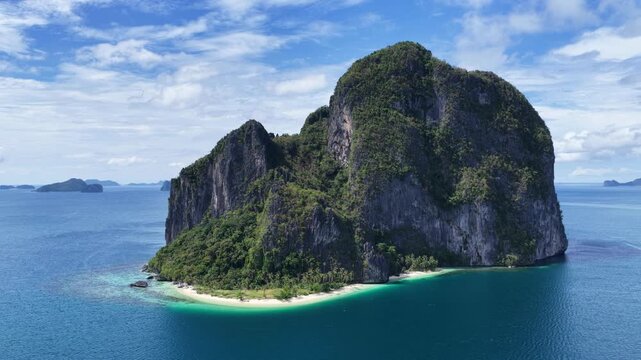 Cinematic aerial video of tropical island in the Philippines with lime stone rock, palm trees and beautiful beach