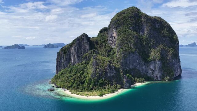 Cinematic aerial video of tropical island in the Philippines with lime stone rock, palm trees and beautiful beach