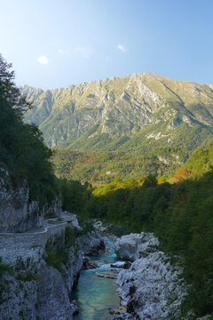 This beautiful mountainous landscape in Slovenia was captured from Napoleon's Bridge in the village of Kobarid, showing the vibrant turquoise Soca River flowing through the rocky alpine valley.