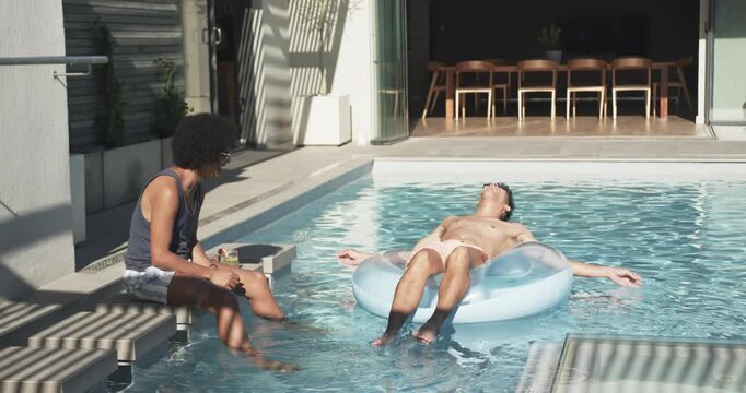 Vertical video: Reaching tray, man in tank making floater on blue ring lifting head smiling at pool